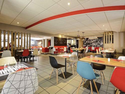 a restaurant with tables and chairs in a restaurant at ibis Poitiers Beaulieu in Poitiers