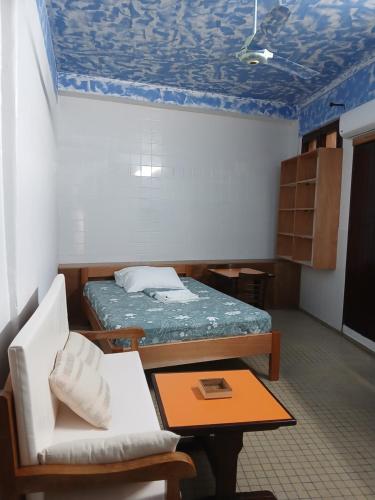 ein Zimmer mit einem Bett, einem Tisch und einem Stuhl in der Unterkunft Claudia STUDIO in Basse-Terre