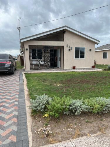 a house with a car parked in front of it at Comfort Rest - Whim in Old Harbour