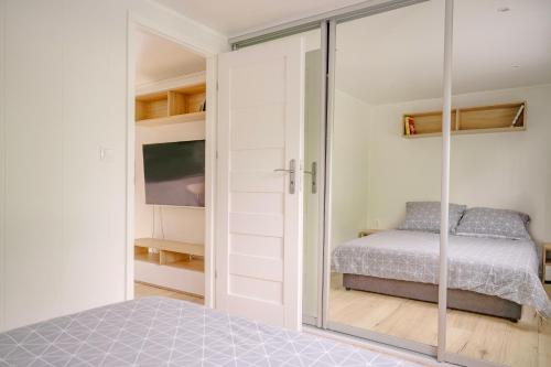 a bedroom with a bed and a sliding glass door at Domek w Suchaczu in Suchacz