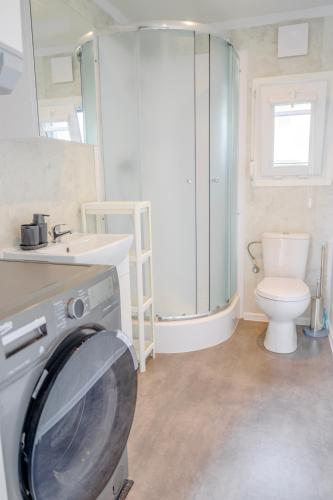 a bathroom with a washing machine and a toilet at Domek w Suchaczu in Suchacz