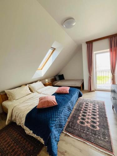a bedroom with a bed with a blue blanket and a rug at Fenyves Appartman in Pécsely