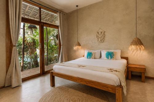 a bedroom with a bed and a large window at The Garten Living in Paje