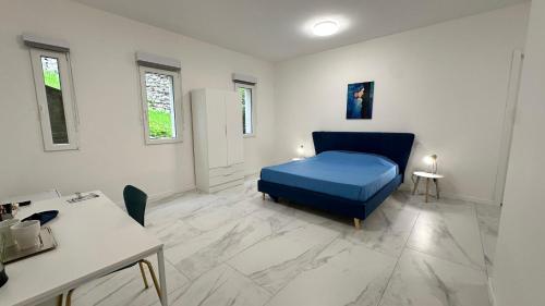 a room with a blue bed and a table at Panorama Terrace - Como Lake in Como