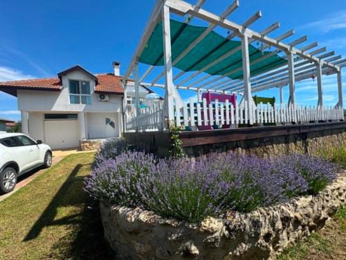 a garden with purple flowers and a white fence at Guest house FantasY in Tyulenovo