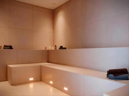a room with a large white bench with lights at Apartamento completo em Ponta de Campina, 2 quartos, piscina, academia e Wi-Fi in Cabedelo