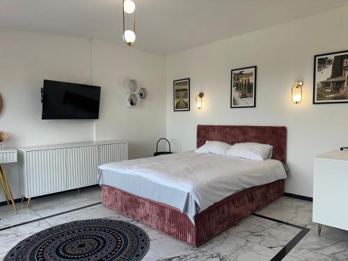 ein Schlafzimmer mit Bett und Flachbildfernseher in der Unterkunft MOVEEN! Apartamenty Wrocław Nowoczesne studia z parkingiem! 10 min od centrum in Breslau
