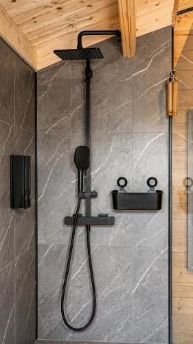 a shower with a black shower head in a bathroom at Bosquet Secret in Froid-Chapelle