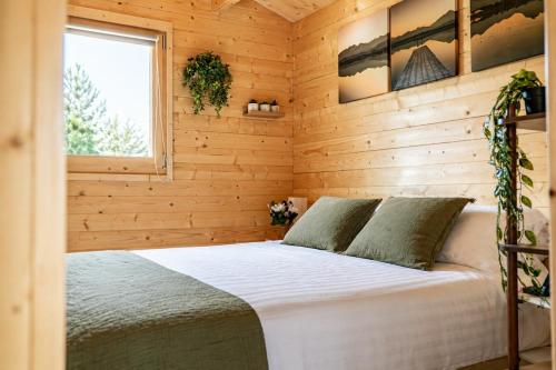 a bedroom with a bed in a wooden cabin at Bosquet Secret in Froid-Chapelle