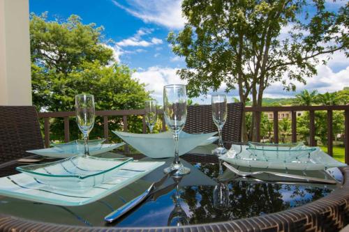a table with wine glasses on top of it at Chic Minimalist Condo with Swimming Pool, Hot Tub, and Beach Club Access in Coco