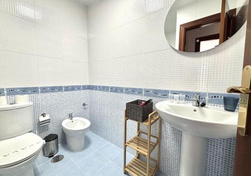 a bathroom with a sink and a toilet and a mirror at Xivares playa in Carrió