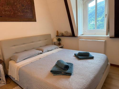 a bedroom with a bed with two towels on it at Castle - A Magic Retreat in Fobello