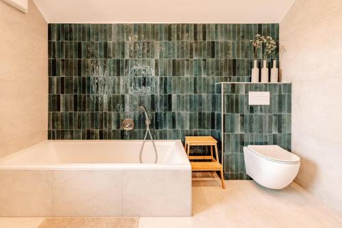a bathroom with a tub and a toilet at Komfortable Familienwohnung in Moosham