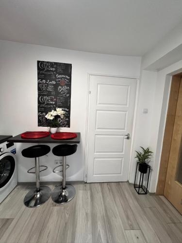 a kitchen with a counter with two stools and a chalkboard at Csillag Vendégház in Debrecen