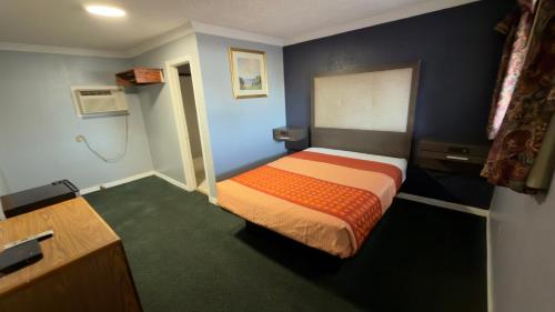 a small room with a bed and a bathroom at Ada Inn & Suites in Ada