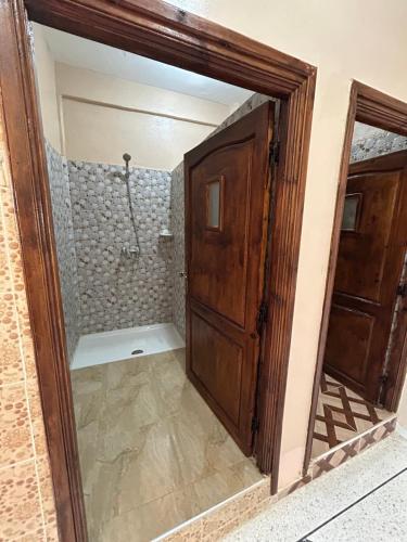 an open door to a shower in a bathroom at Sunlight guest house in Taghazout
