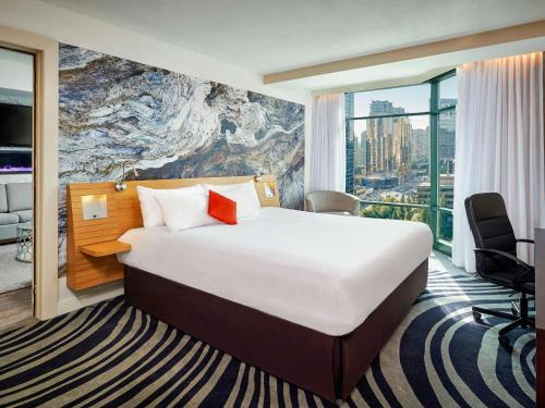 a hotel room with a bed and a large window at Novotel Toronto North York in Toronto