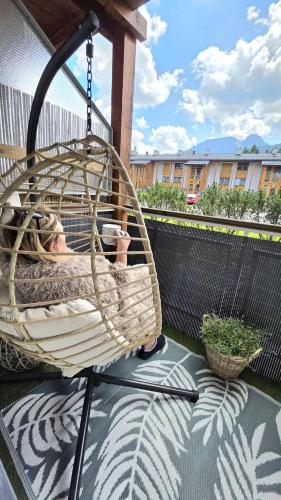 a person sitting in a hammock on a balcony at Tatrzańska Prowansja SPA&SKI Apartamenty in Zakopane