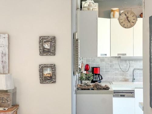 a kitchen with white cabinets and a clock on the wall at Boho Mare Retreat - Skala Fourkas in Skala Fourkas