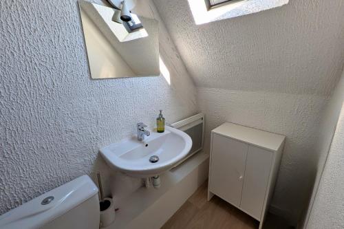 a white bathroom with a sink and a mirror at Spacious Loft - Quiet and Bright in Soultz-Haut-Rhin