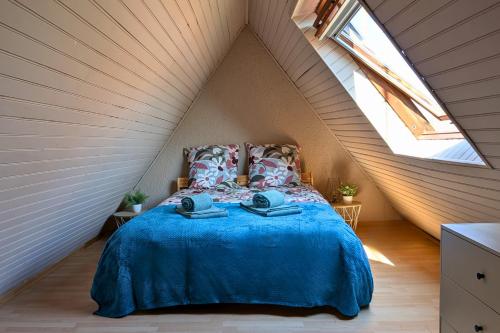 a bedroom with a blue bed in a attic at Spacious Loft - Quiet and Bright in Soultz-Haut-Rhin