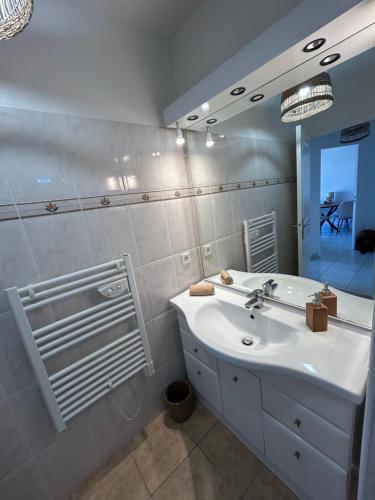 a bathroom with a white sink and a mirror at Appartement frejus in Fréjus