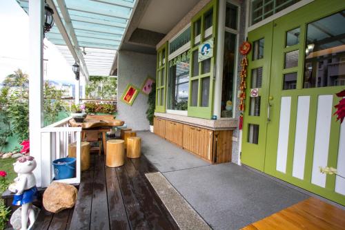 a porch of a house with a green door and a table at Vicking Guesthouse in Taitung City