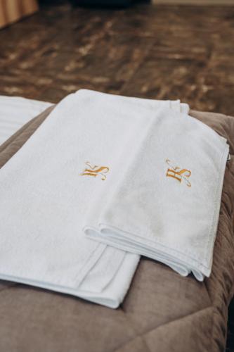 two white towels sitting on top of a bed at Hiking&Ski Hotel in Bukovel
