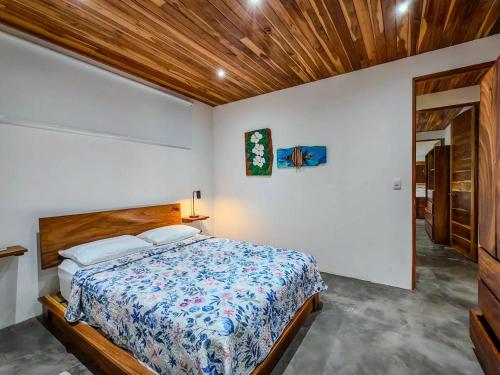 a bedroom with a bed and a wooden ceiling at Samara by the River Vacation Suites in Sámara