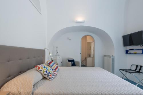 a bedroom with a large bed in a white room at Levante - charming apartment with sea-view terrace, fits up to 7 guests in Maiori