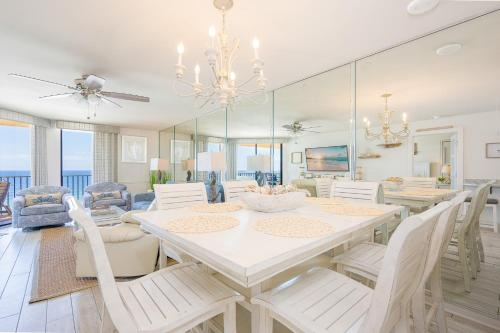 a dining room with a white table and chairs at Phoenix V 916 in Orange Beach