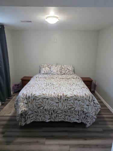 a bedroom with a bed with a comforter on it at Bright Cozy 2-Bedroom Main Floor Suite in Brampton