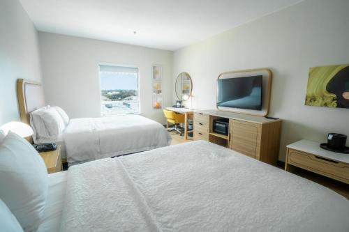 a hotel room with two beds and a flat screen tv at Hampton Inn & Suites Mission in Mission