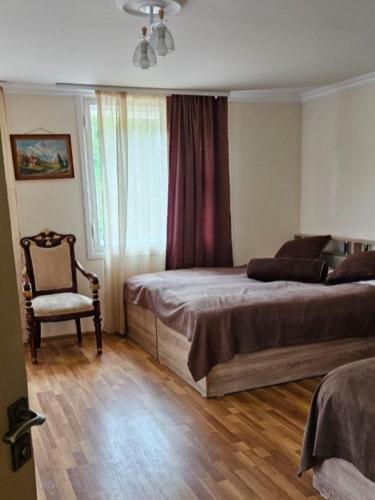 a bedroom with a bed and a chair and a window at Rich Garden House in Vanadzor
