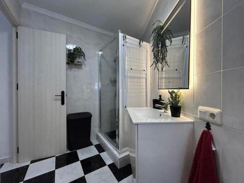 a white bathroom with a sink and a shower at Isabella Chipiona in Chipiona
