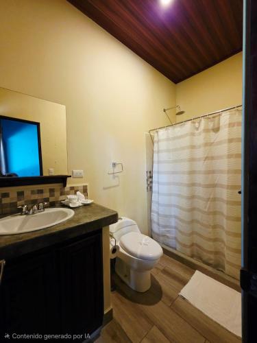 a bathroom with a toilet and a sink and a shower at Senda Adults Only Hostel in Manuel Antonio