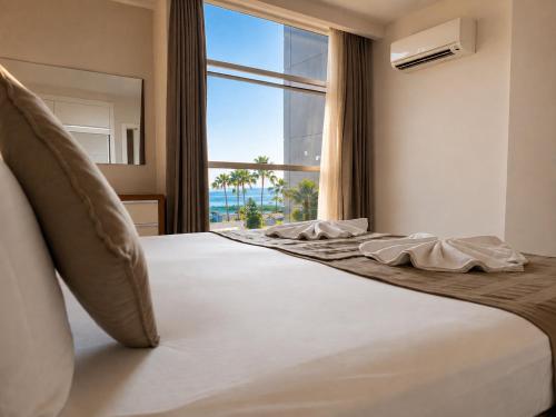 a bedroom with a large bed with a large window at Delfino Apart Hotel in Alanya