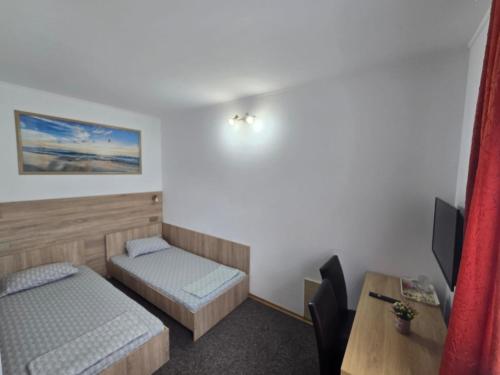 a small room with two beds and a table at Casa Diadeea Motru in Motru