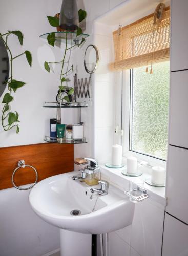 a bathroom with a white sink and a window at Century Apartments Manchester in Dukinfield