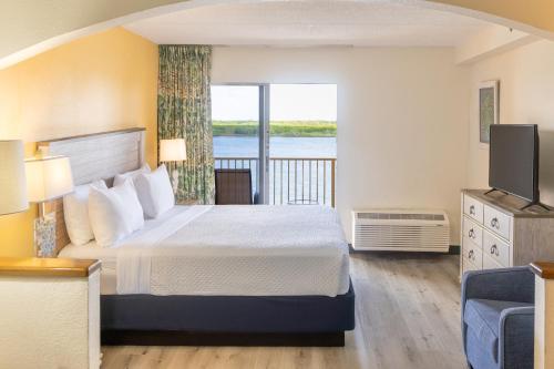 a hotel room with a bed and a balcony at Hutchinson Island Hotel in Fort Pierce