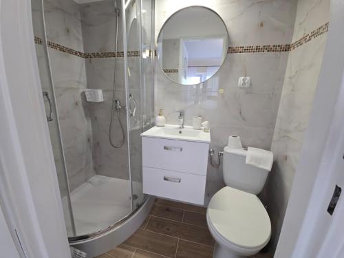 a bathroom with a toilet and a shower and a sink at Mirato in Władysławowo