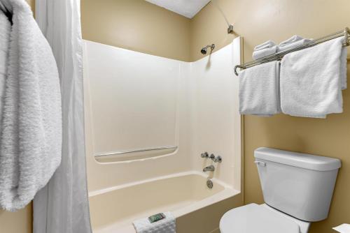 a bathroom with a toilet and a shower with towels at SureStay Plus Hotel by Best Western Salmon Arm in Salmon Arm