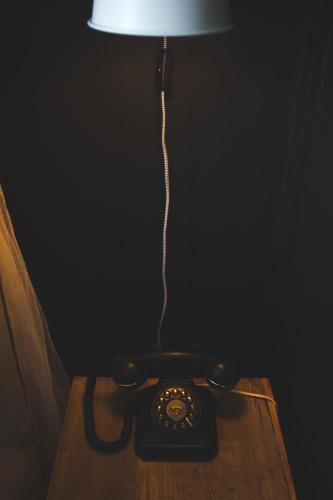 a lamp on a table with a phone on it at Hotel Palisade in Sydney