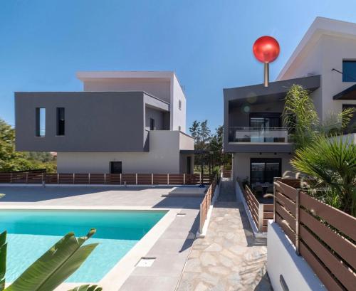 a villa with a swimming pool in front of a house at Diamond Gold Suite in Iraklitsa