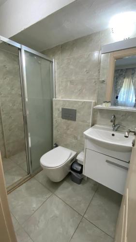 a bathroom with a toilet and a sink and a shower at orhan pansiyon in Çeşme