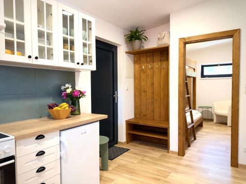 a kitchen with white cabinets and a door to a room at JUNÁK MINI ubytování v soukromí in Vranov nad Dyjí