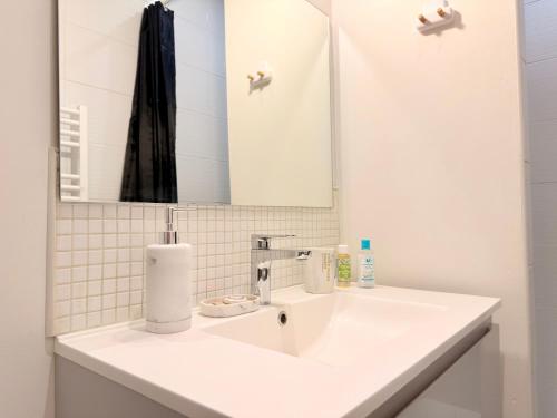 a bathroom with a white sink and a mirror at Le Chamily in Besançon