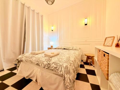 a bedroom with a bed and a checkered floor at Le Chamily in Besançon