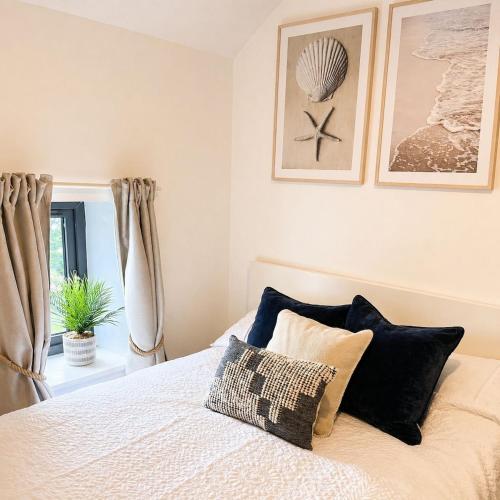 a bedroom with a bed with pillows and a window at Rose Cottage, Killala in Killala