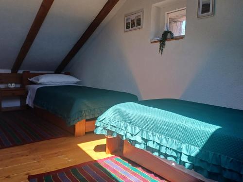 a bedroom with two beds with green comforters at Terra Verde in Omiš